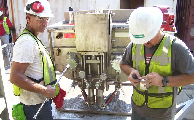 Technicians maintenance patented epoxy pump at port facility