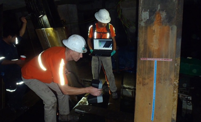 Technicians using a photogrammetric scanner to assess section loss of piles
