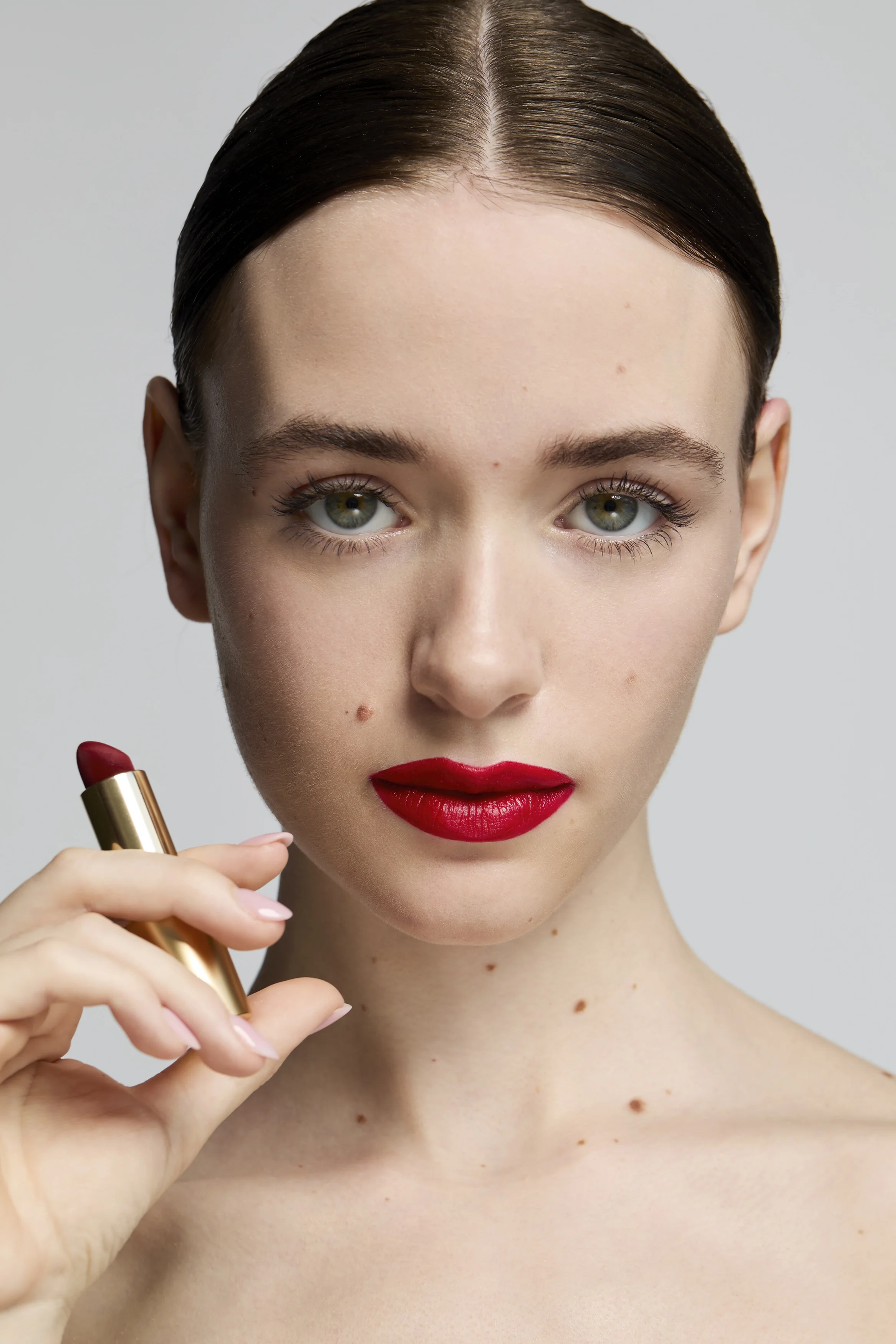  beauty shot of a model with red lip, holding red lipstick,  skincare photoshoot, beauty photography, skincare photography, Egle Vasi, beauty photographer, beauty photographer London, beauty photographer Bristol 
