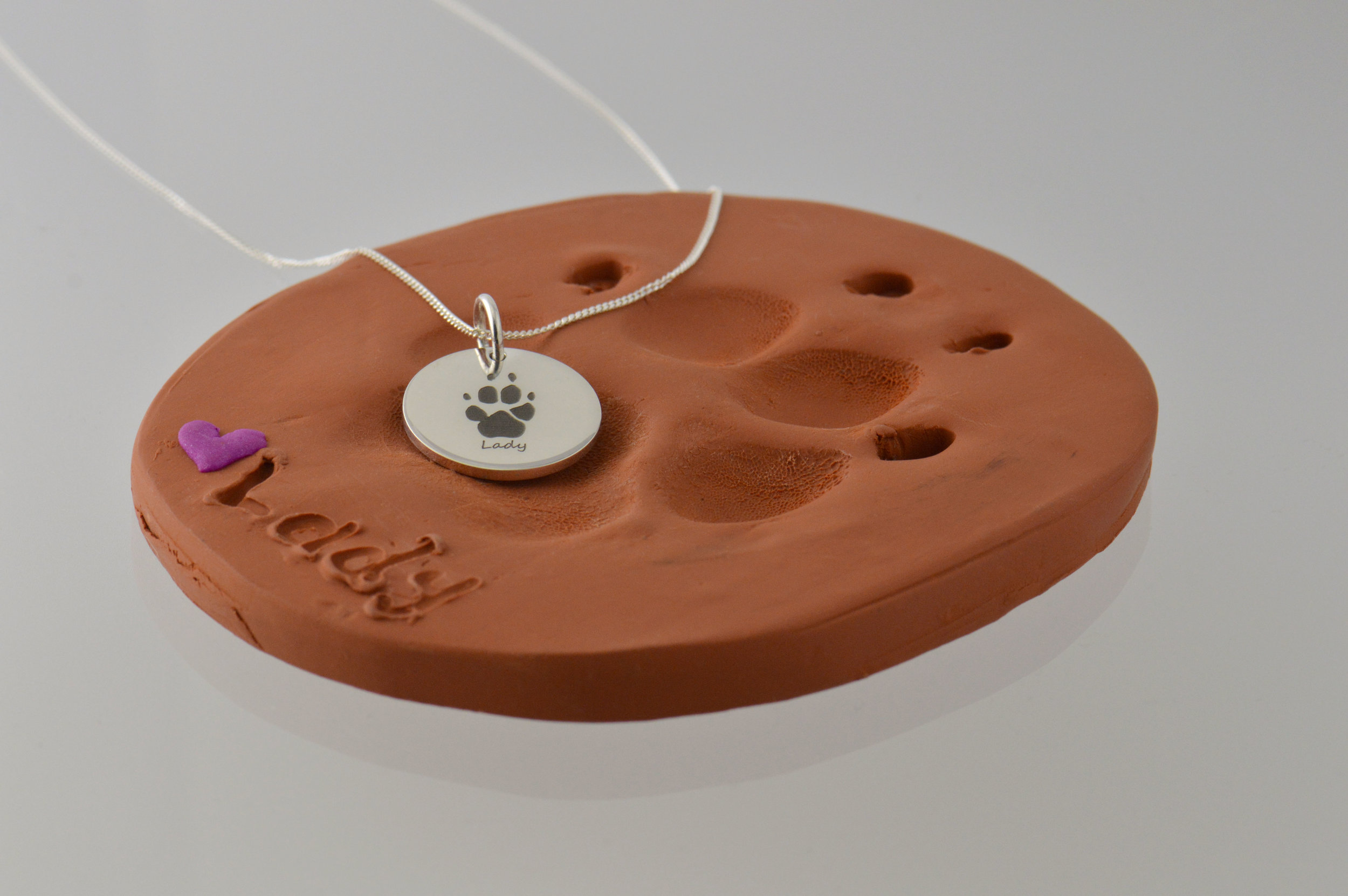 Remembrance paw print engraved pendant.