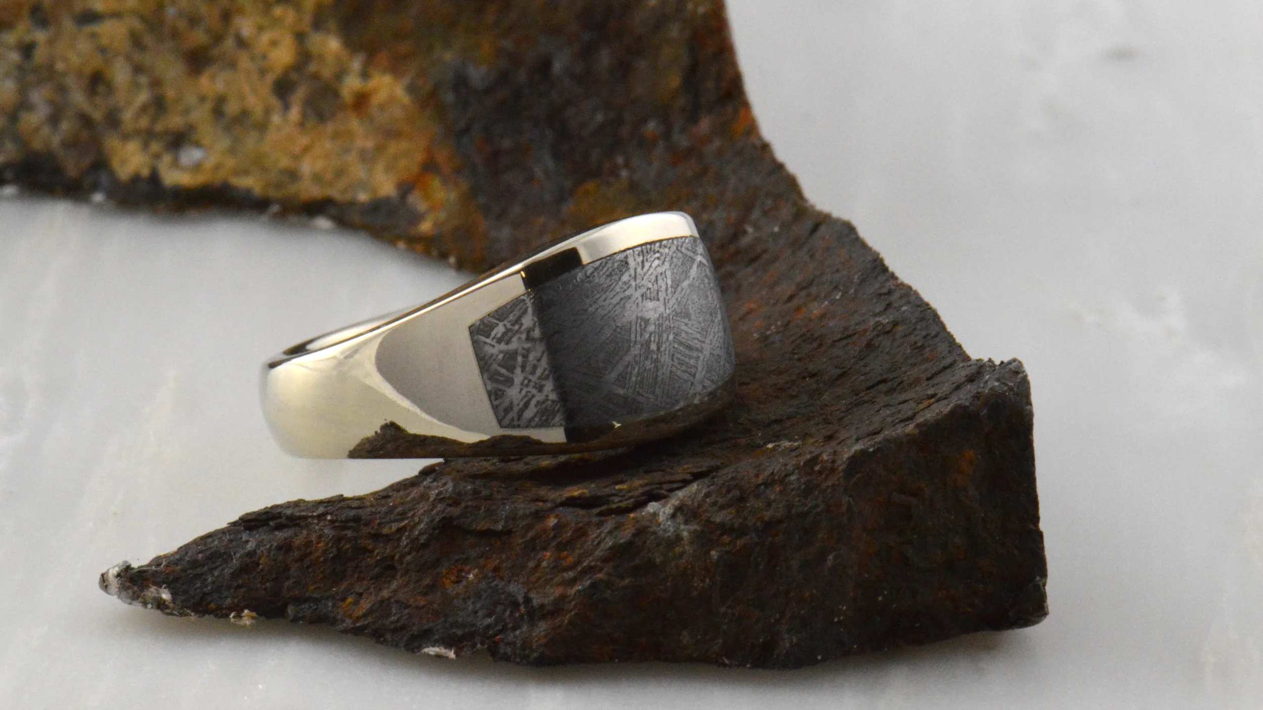 Gibeon Meteorite. Very rare, discovered in Nambia in 1838 and once machined into your ring it displays the incredible Widmanstätten pattern you see here. The unique finish you see in the gold ring above developed while entering our atmosphere in micro-gravity in pre-historic times. Once our modest stock is depleted, I will not be able to reliably replace it. That will be the end of this chapter in our custom production.