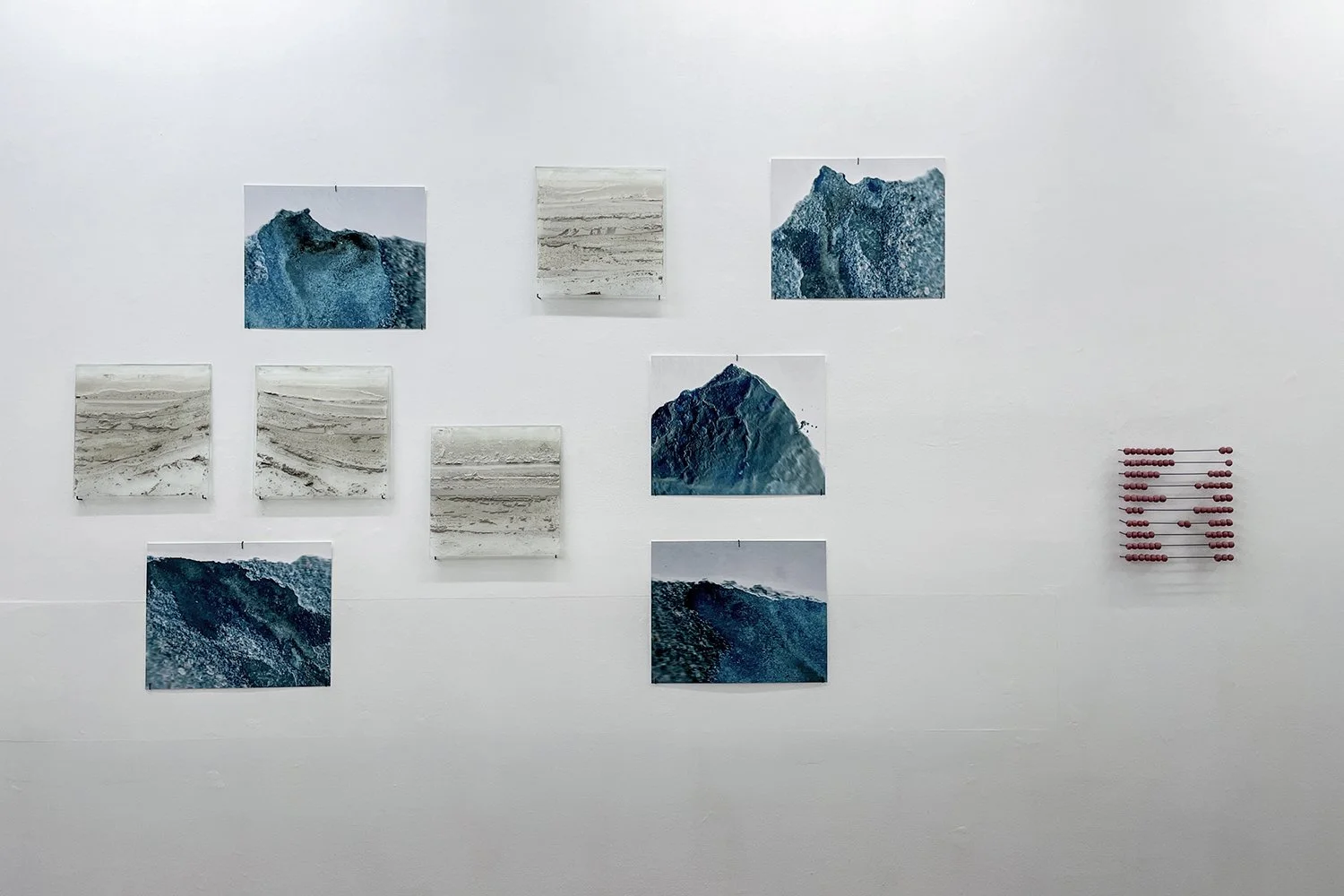   Anløpninger (2023)   Series of scans and stained glass plates.  To the left:  1-100  (2023) Cement, red pigment, steel. 