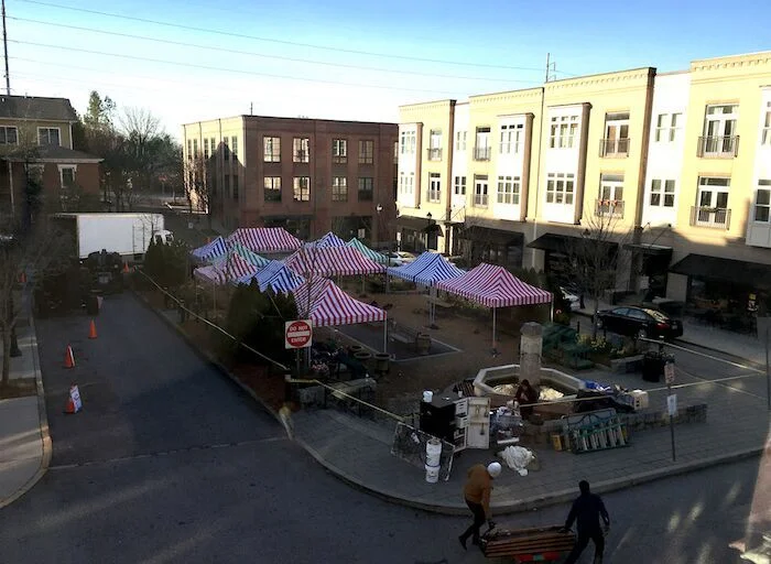 BEGINNING TO CREATE THE MARKET, STARTING WITH BRIGHT STRIPED TENTS. 