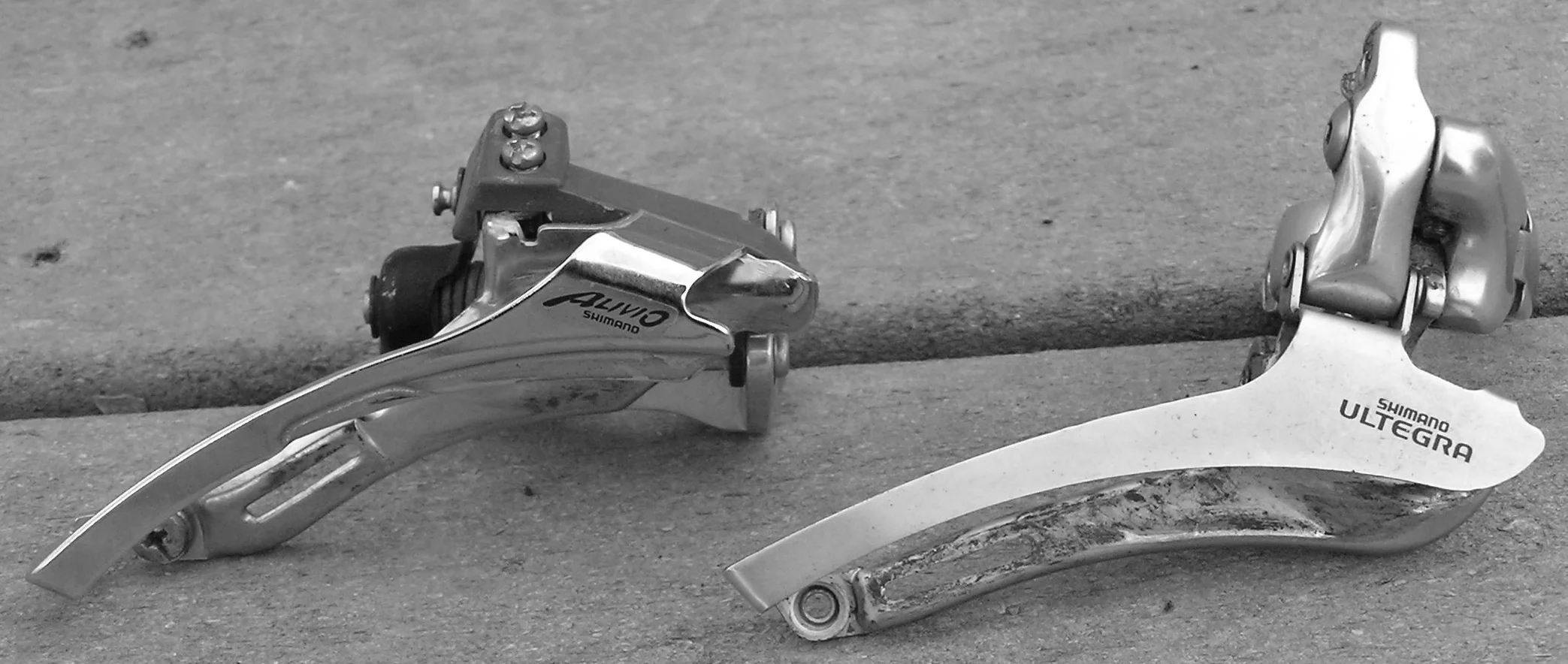 Figure 3: Two front derailleurs. The derailleur on the left has a clamp lower than the top of the cage.