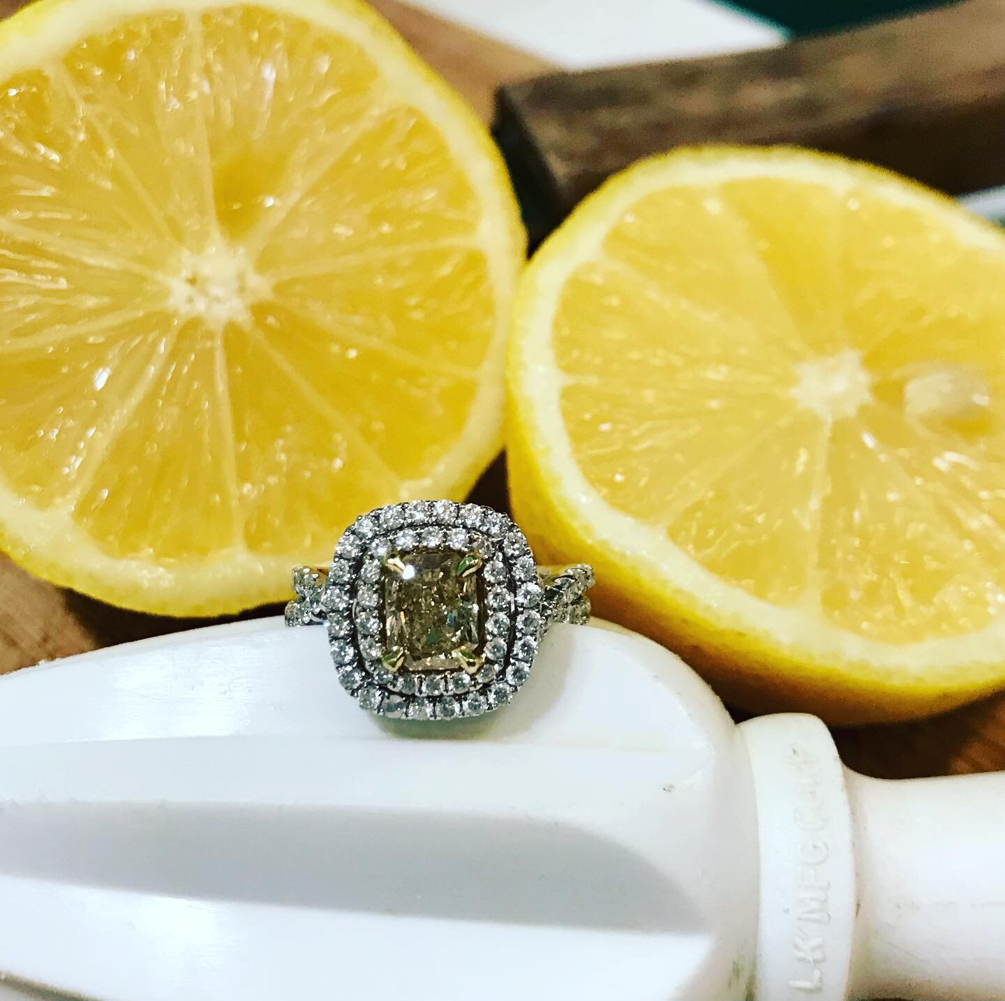 When life gives you lemons... Gorgeous 1.51 carat fancy yellow princess cut diamond in an 18k white gold halo setting with .92 tcw white diamonds. Sweet!