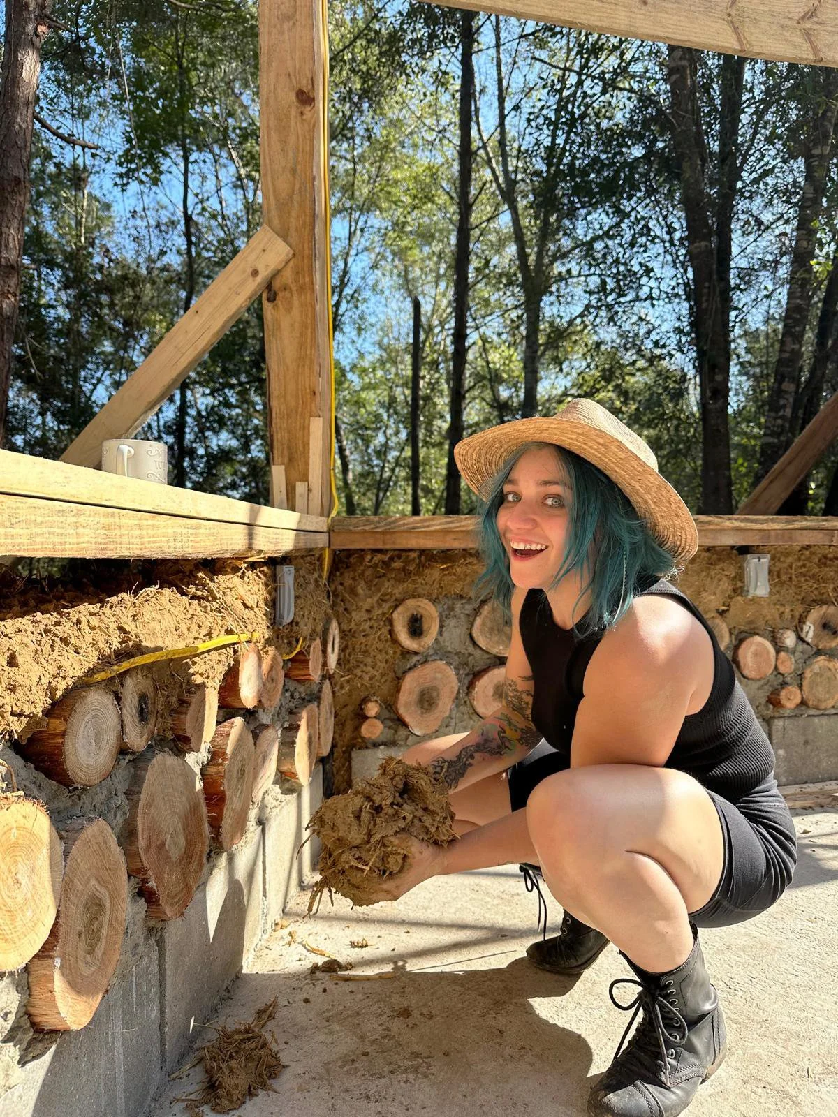 Building with cob and cordwood at EarthRise Collective, Iffy Roma, Program Director for Habitat Recovery Project, blends natural materials into functional art. This work supports sustainable construction and community-focused, earth-centered design.
