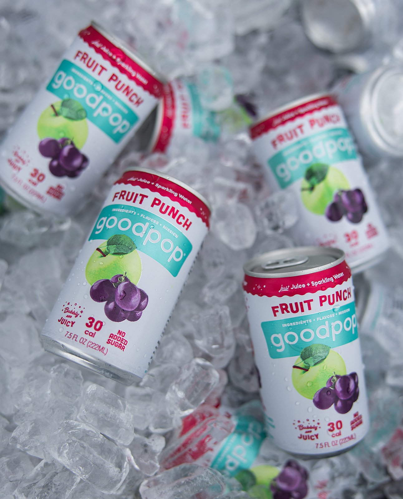 Several cans of GoodPop Fruit Punch frozen fruit juice popsicles on a bed of ice.