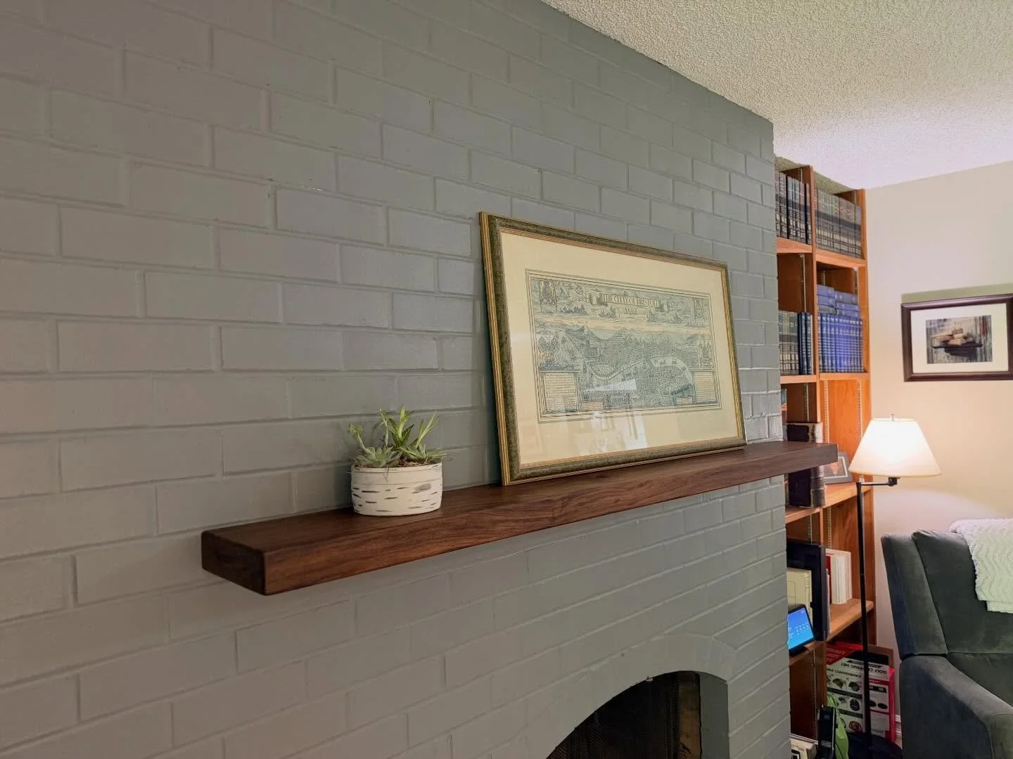 Solid floating Walnut fireplace mantle and a companion floating cube shelf.  Float on.  #fireplace #mantle #floatingshelves #walnut #customfurniture
