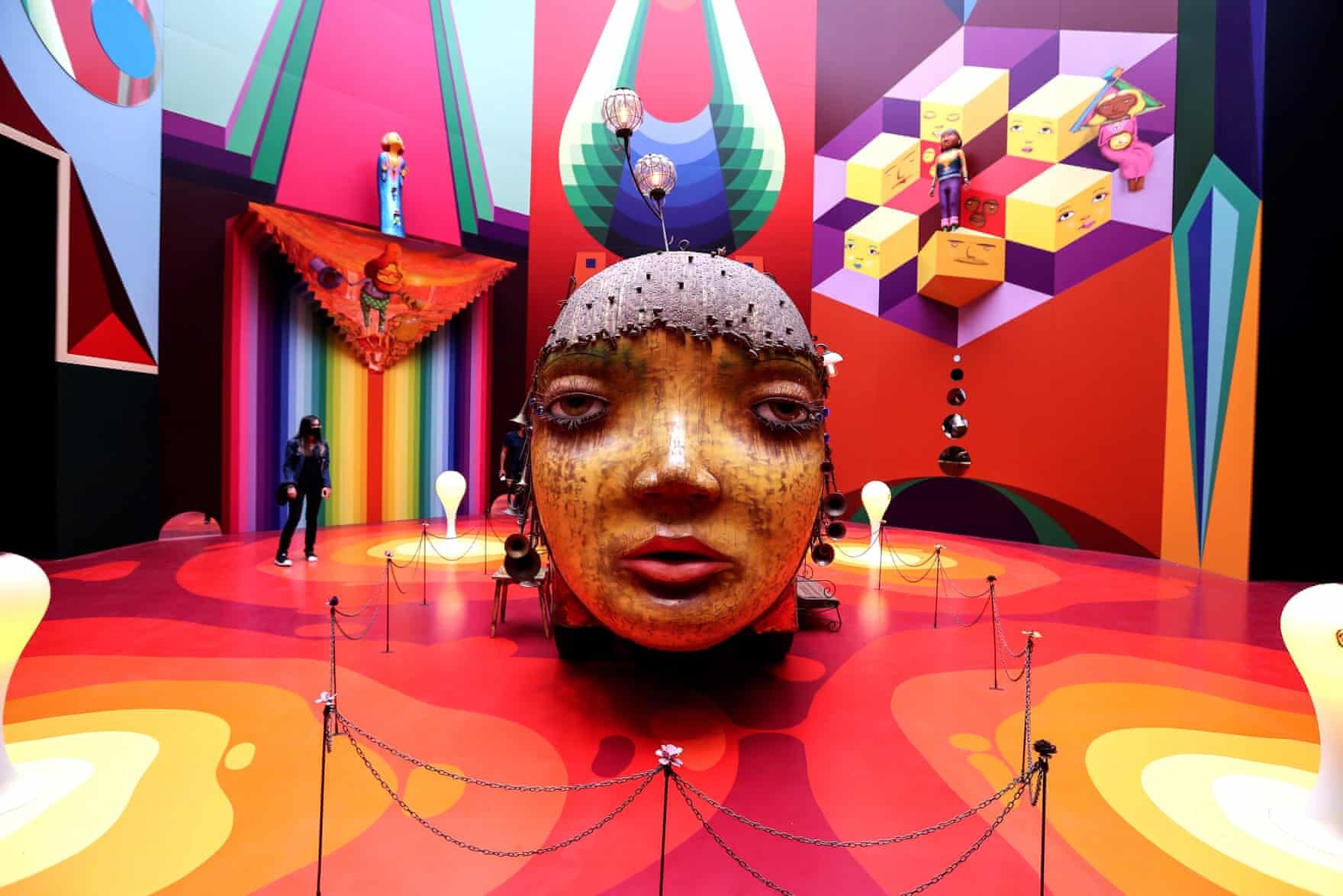 São Paulo, Brasil   Um visitante vê uma obra que faz parte da mostra OsGemeos, intitulada Secretos. A mostra marcou a volta da vida cultural em São Paulo após sete meses de inatividade por conta da pandemia e apresenta objetos pessoais e obras dos artistas de rua brasileiros Otavio e Gustavo Pandolfo, também conhecidos como OsGemeos.  Foto: Sebastião Moreira / EPA