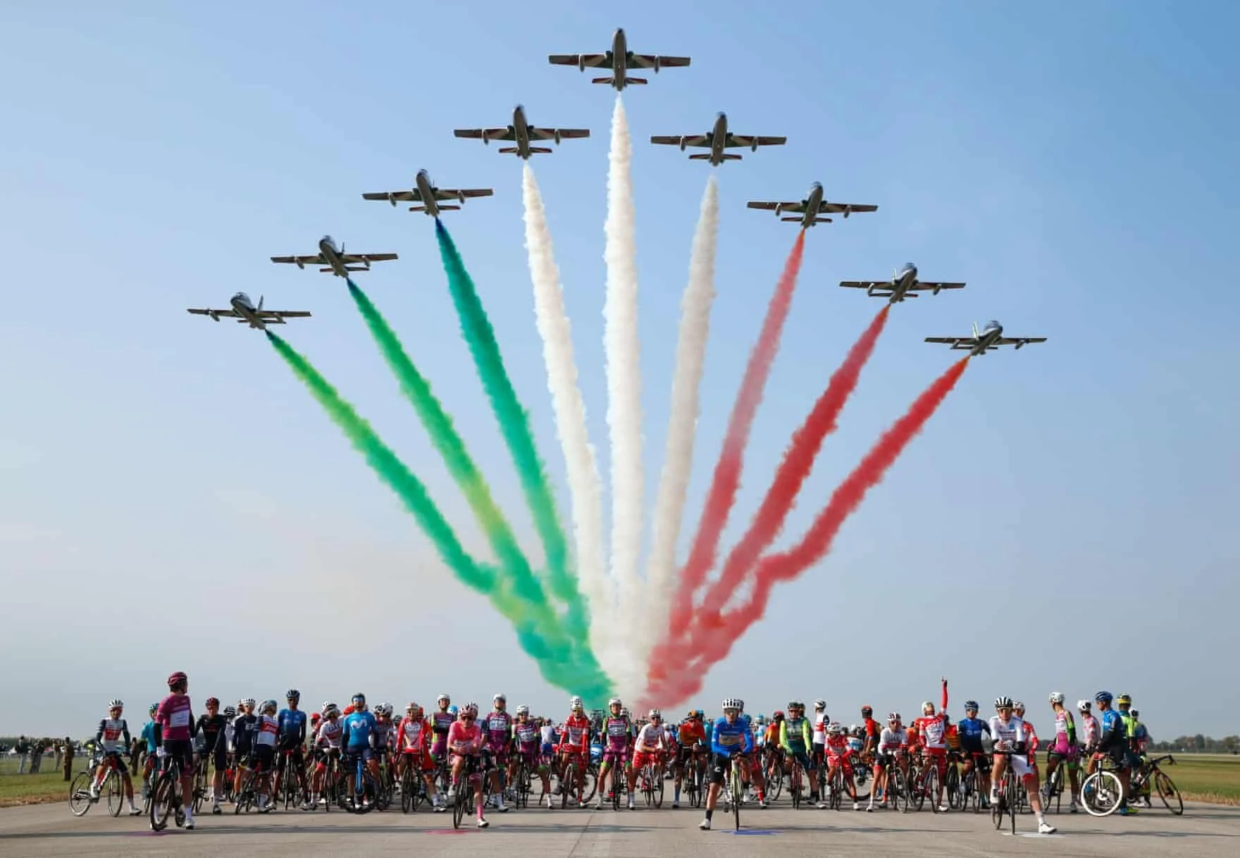 Codroipo, Itália   Ciclistas esperam enquanto a unidade acrobática da força aérea italiana Frecce Tricolori (Setas Tricolor) se apresenta durante a 15ª etapa da corrida de ciclismo Giro d'Italia.  Foto: AFP / Getty Images