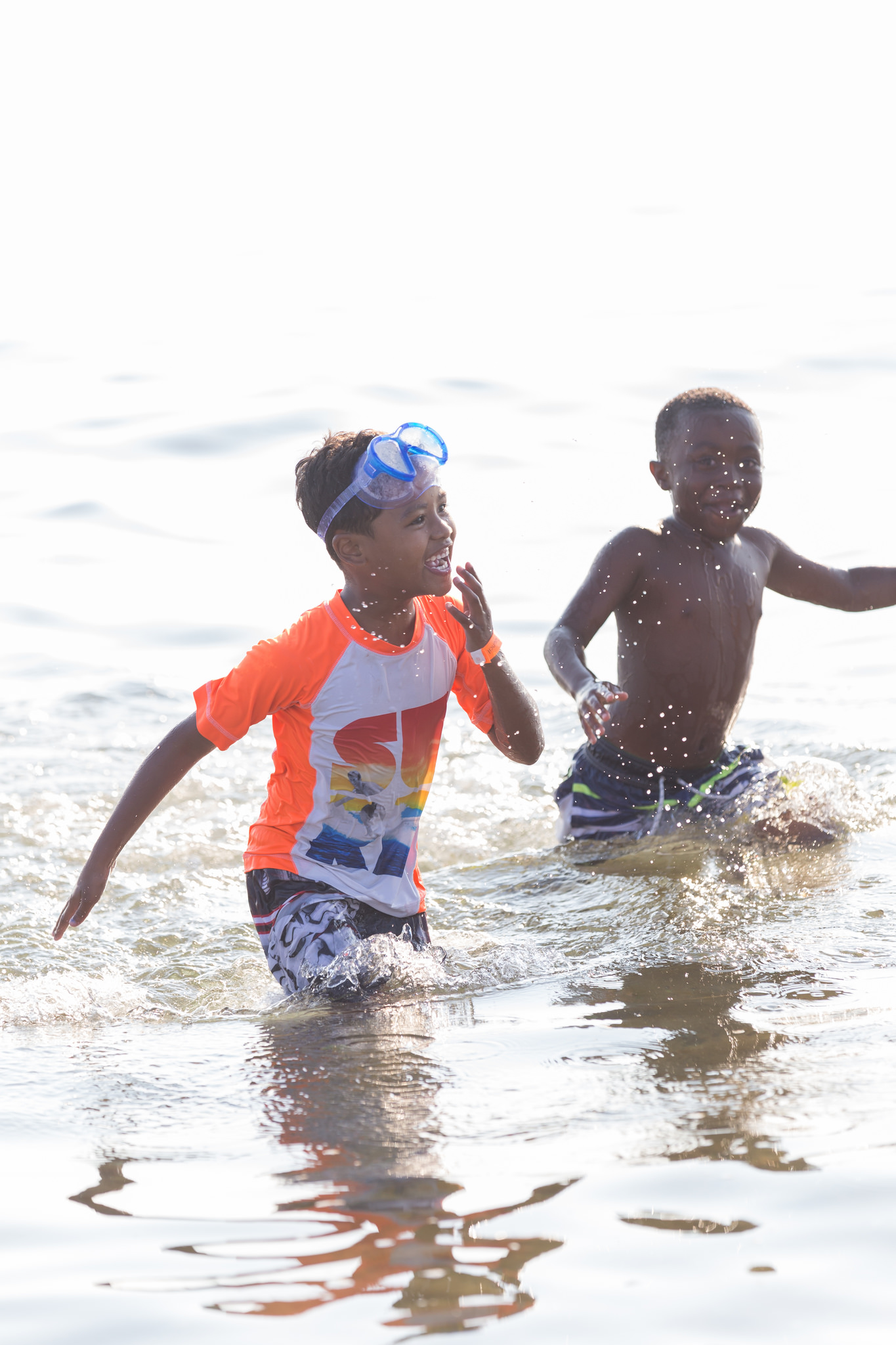 Two kiddos splashing through the ocean