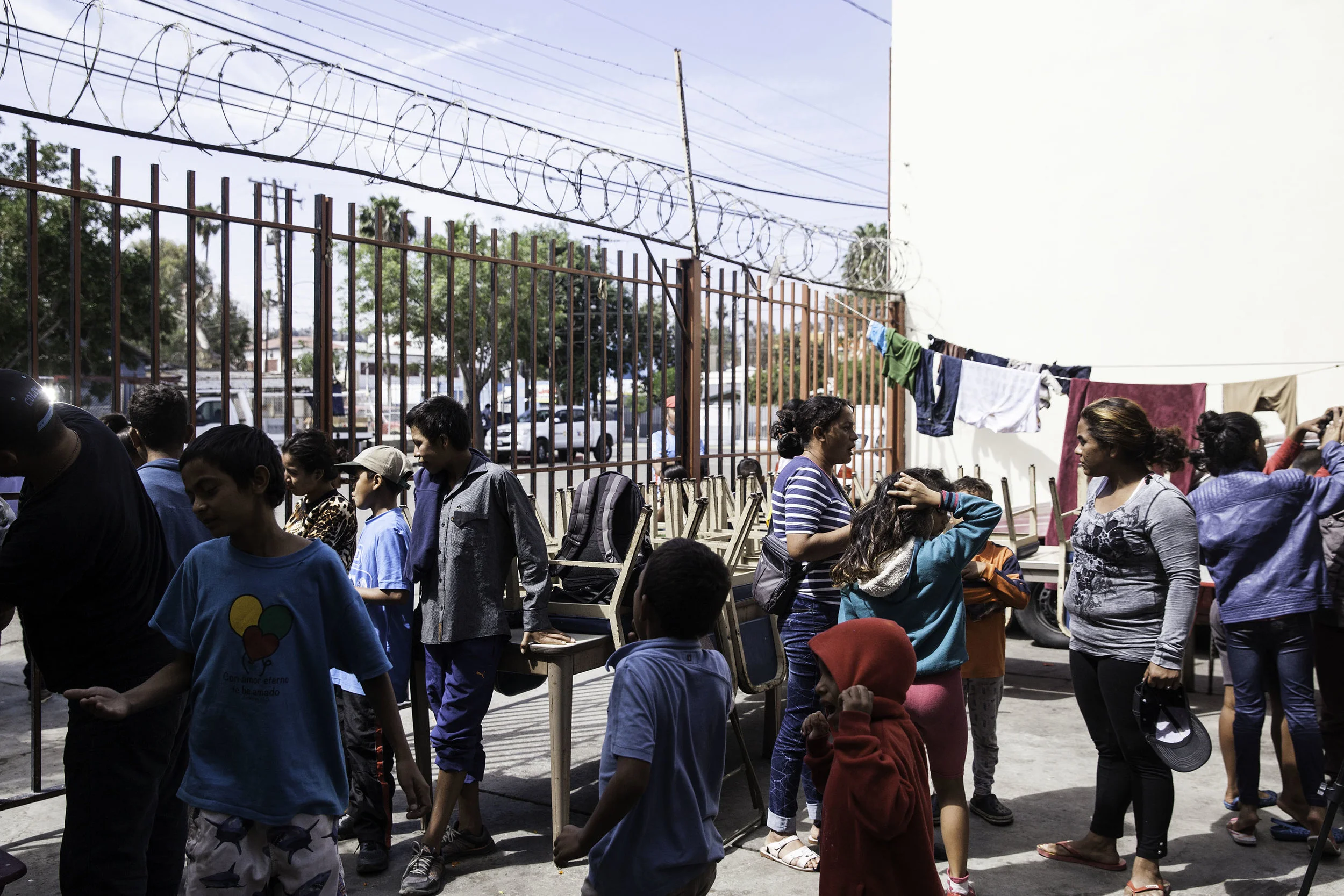 After spending their first night at Viña de Cristo shelter in Tijuana, MX, women talk to one another, children play outside on April 26, 2018.