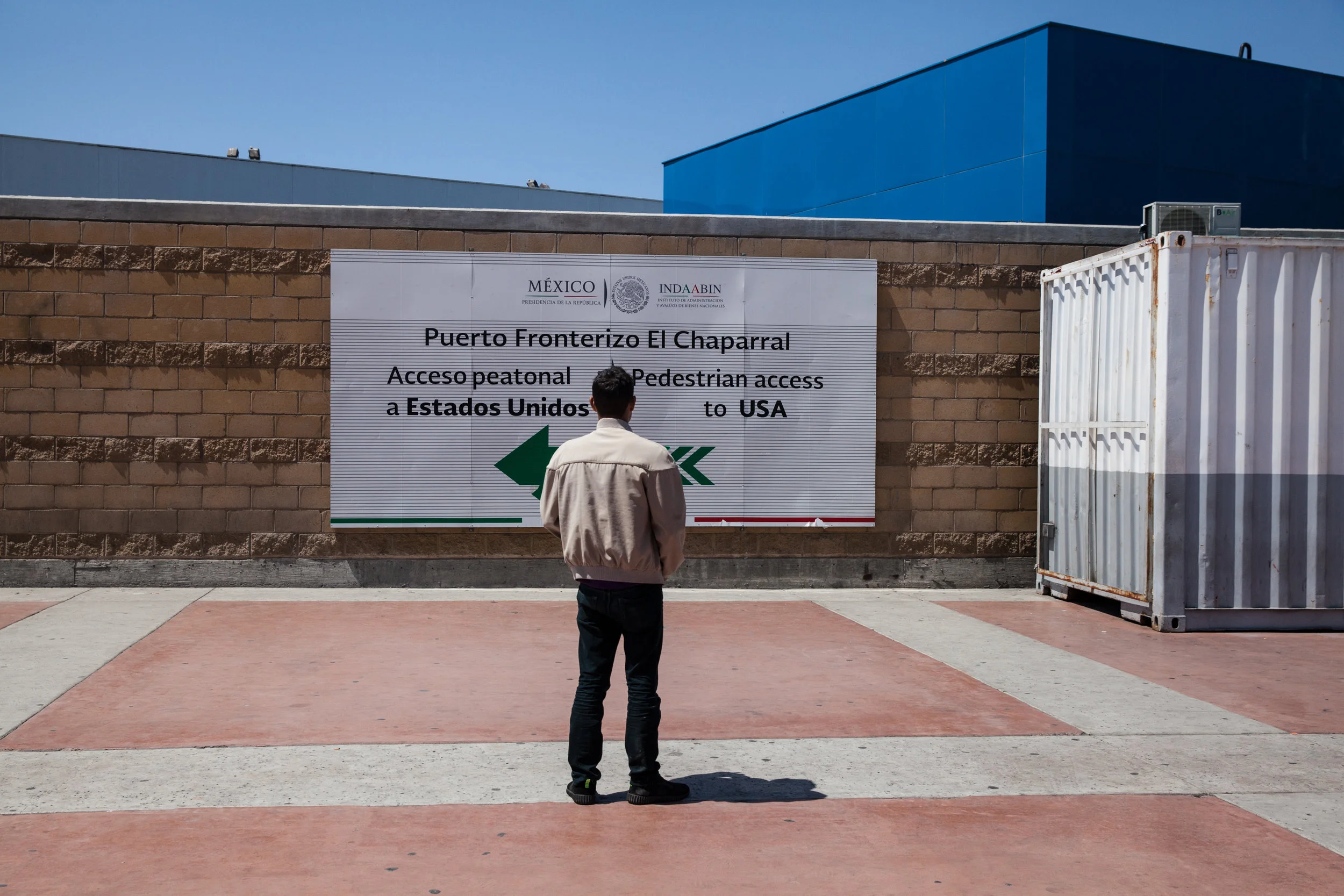 Noel, 17 years old from Honduras has been traveling with his mom and his younger brother whose 14 years old. They are hoping to seek asylum in the U.S and make their way to San Francisco. Noel looks at the Port of Entry sign to the United States from Tijuana on April 28, 2018.