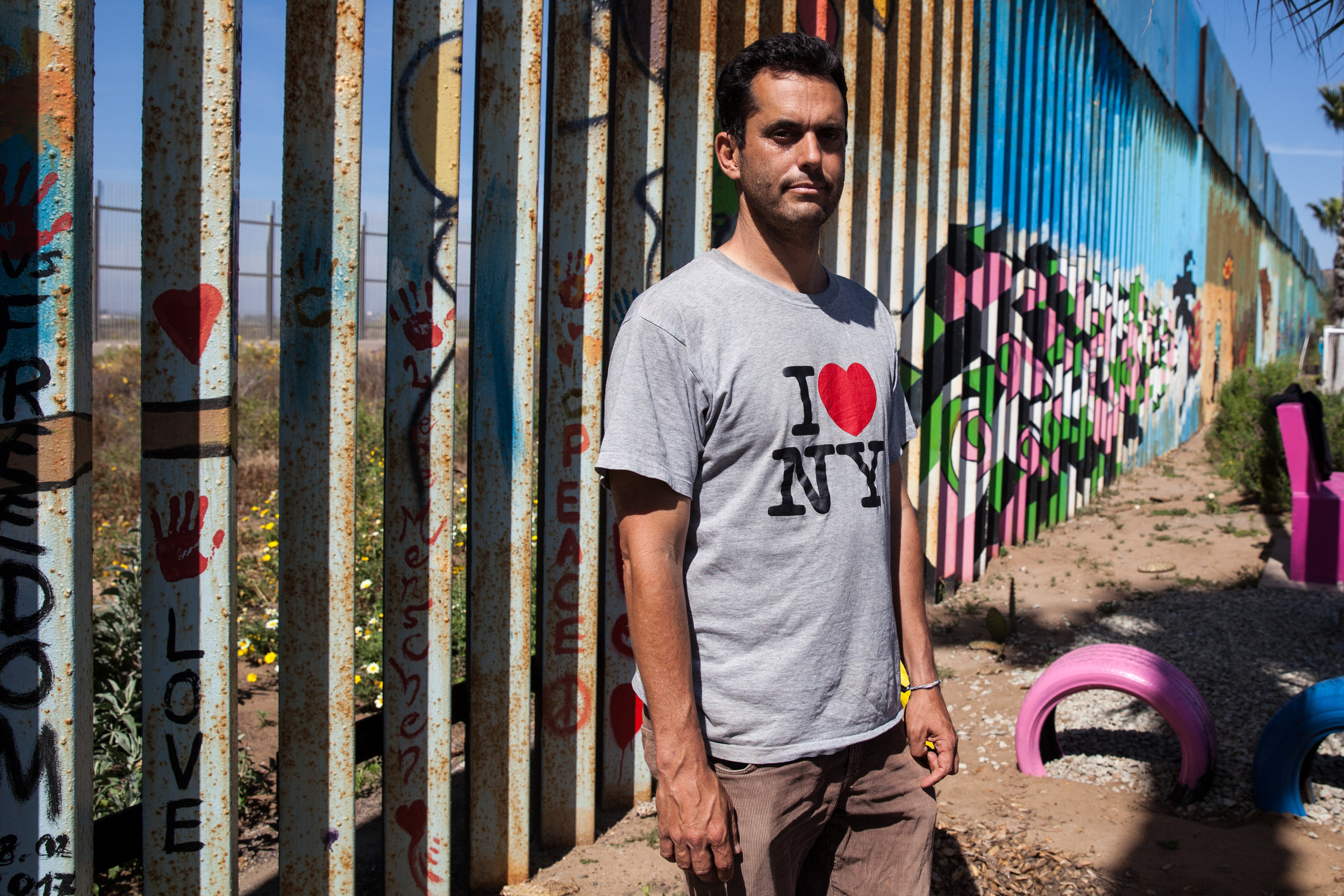 Dan Watman grew up in Modesto, California. Watman teaches Spanish across the border in Imperial Beach and lives in Tijuana, MX. He started the garden in 2007 that grows on both sides of the fence through a group he founded, Border Encuentro, the goal is to build friendships between both countries. On the Tijuana side the garden includes vegetables for the hungry. The garden grows within three circular plots, two that are about ten feet in diameter and one that is about thirty feet in diameter. Dan stands in the garden in Playas de Tijuana, Mexico.