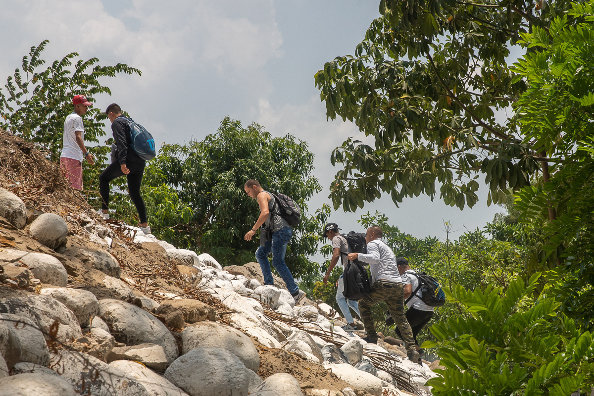Migrants follow a smuggler after riding an inflatable raft on the Suchiate River from Tecun Uman, Guatemala to Ciudad Hidalgo, Mexico on May 9, 2019.