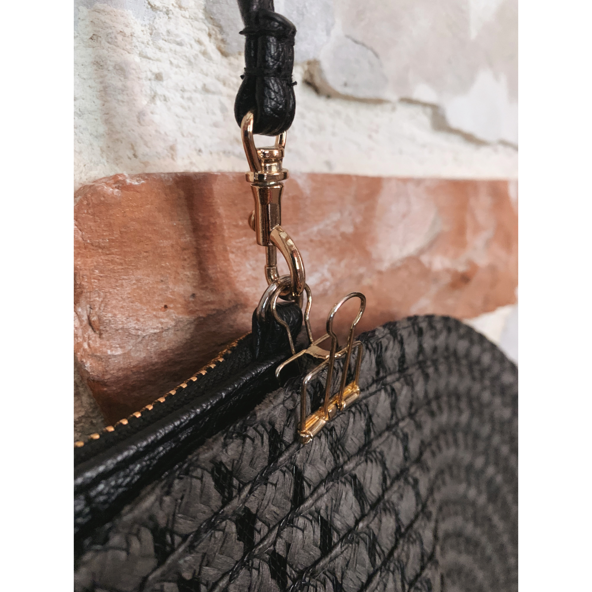 Upclose image of clip used to clip hat to small purse