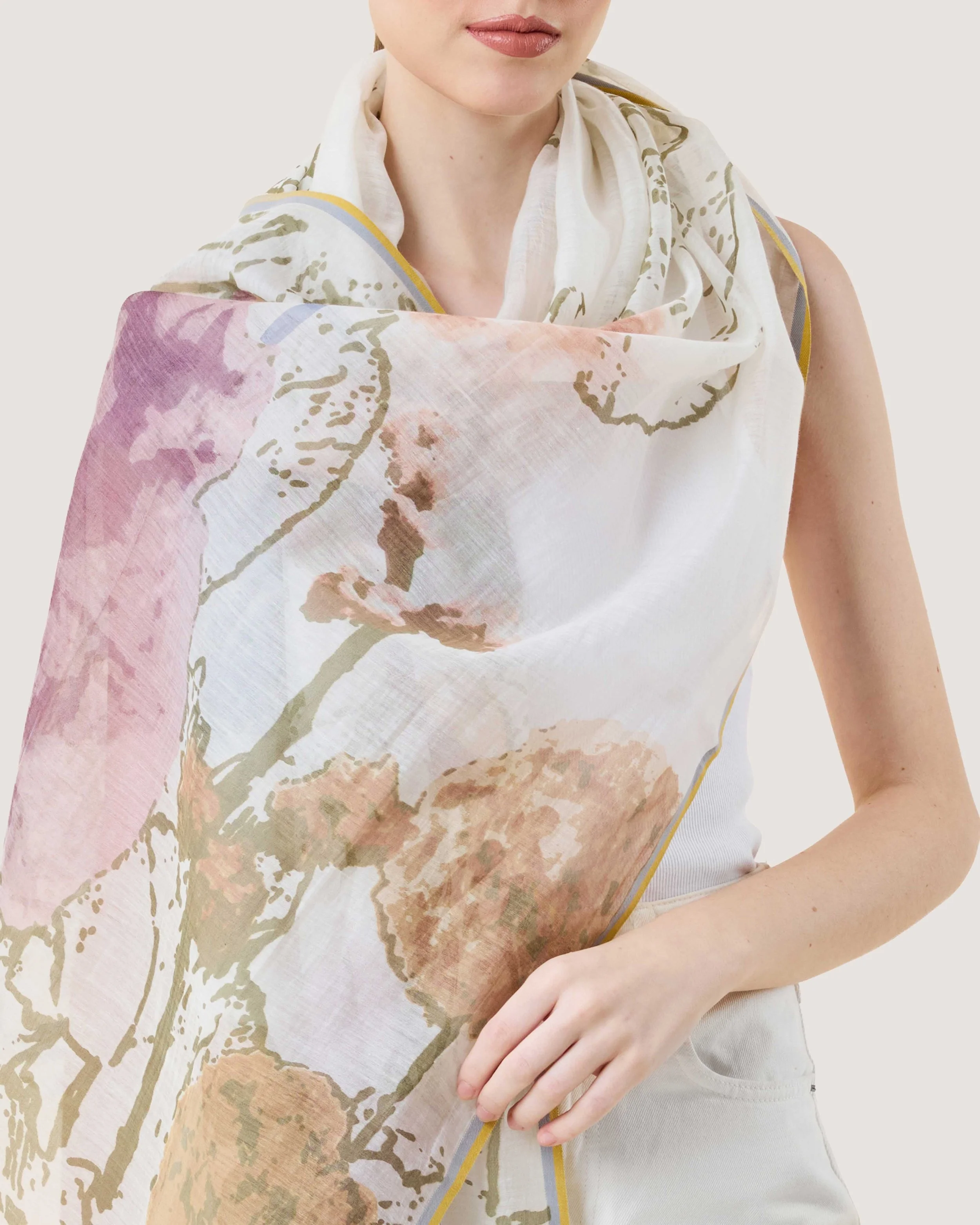 Closeup of the Spring Foliage Hand-Printed Scarf in floral designs in multiple pastel colour wrapped around a woman. Made from Cotton and Silk by DLUX