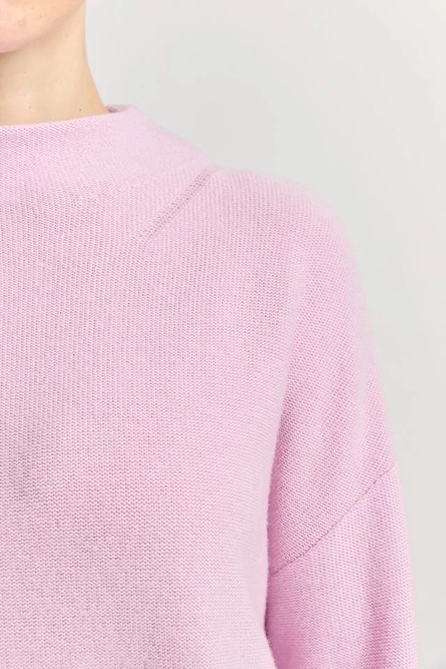 Closeup of the neckline and stitching of the Powder Pink colour variant of the Toorallie Drop Shoulder Mock Neck Sweater made from 100% Merino lambswool)