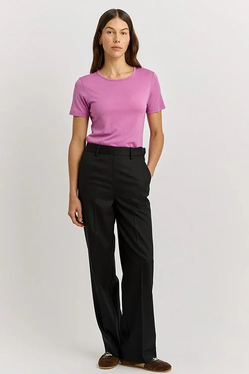 Woman wearing the Ultra Violet colour variant of the Toorallie Short Sleeve Crew Tee, made from Merino Wool)