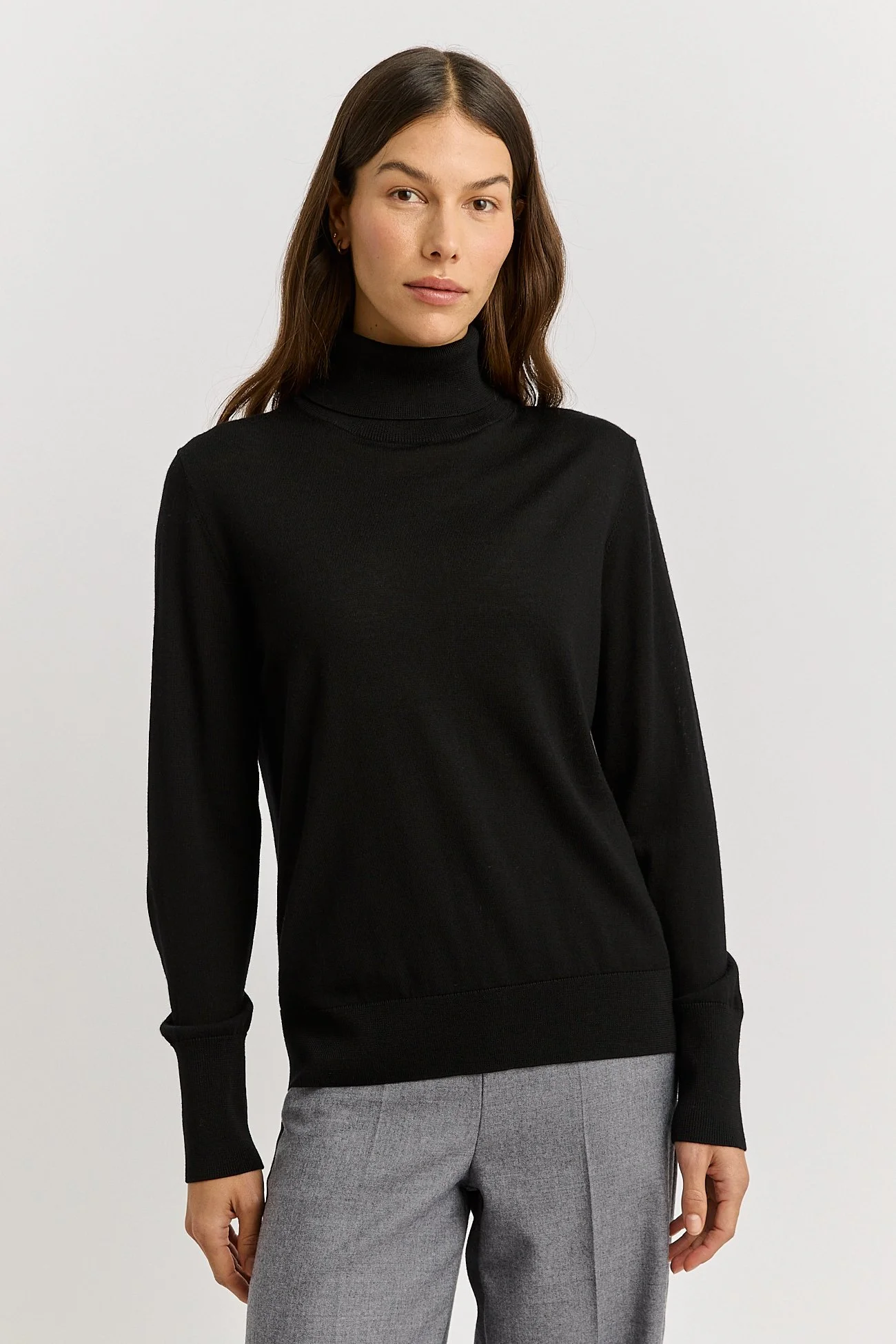 Woman wearing the black colour variant of the Toorallie Extra Fine Turtle Neck Jumper