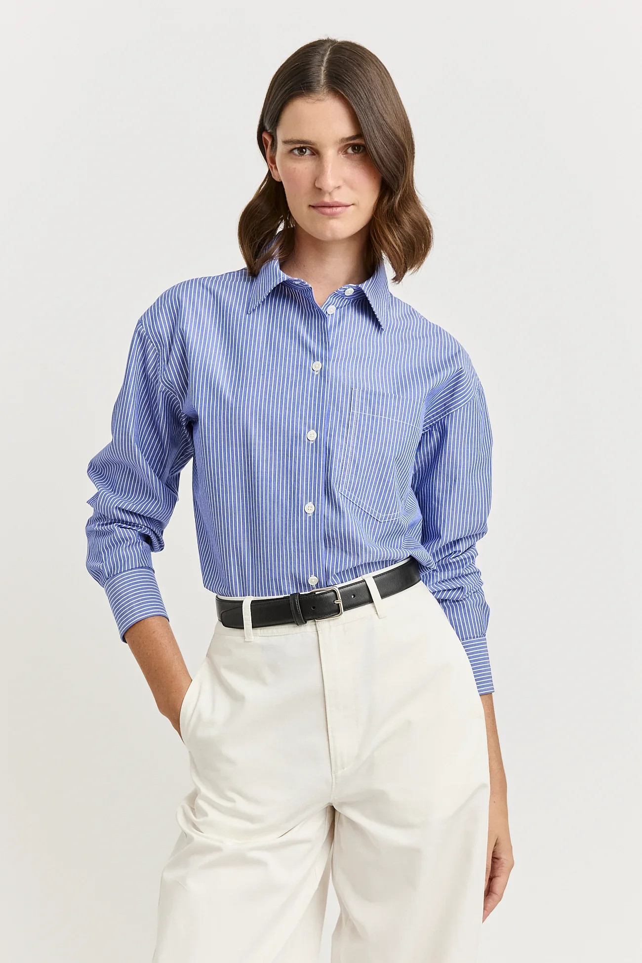 Woman wearing the blue and white stripe variant of the Toorallie Relaxed Cotton Shirt made from 100% Cotton)