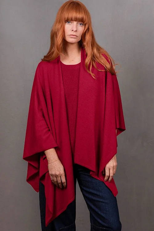 Woman wearing the Cassis (rich dark red) colour variant of the Wrap Topper made from Merino wool and cashmere from Bridge & Lord