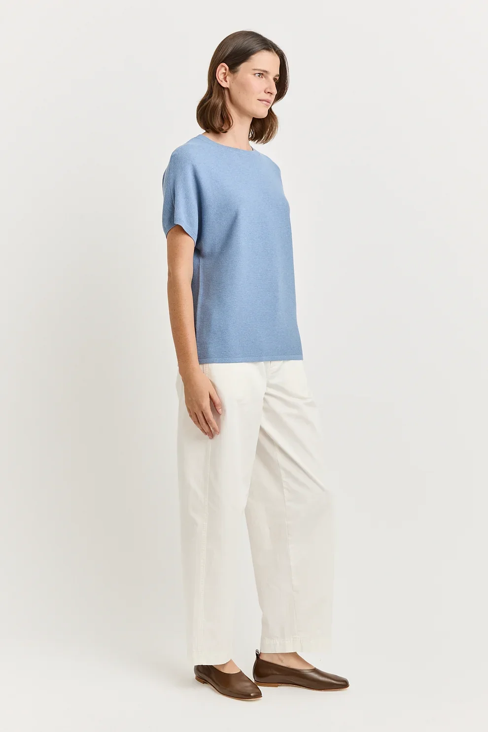 Full view of a woman wearing the Mist ( blue) colour variant of the Toorallie Links Cap Sleeve Top made from Organic Cotton and Merino