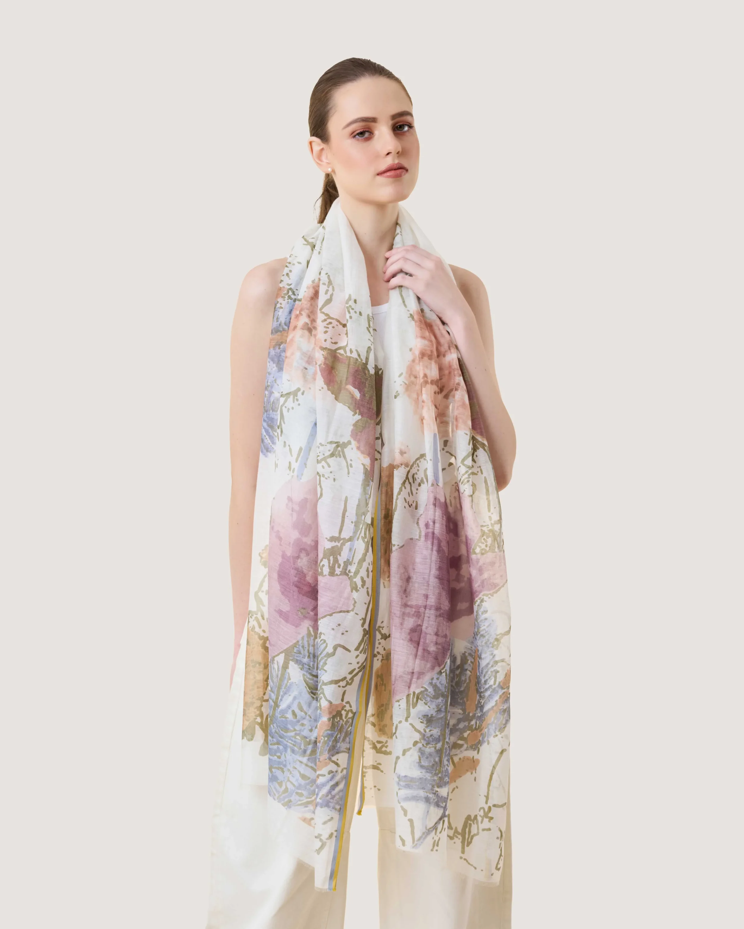 Product image of a woman wearing Spring Foliage Hand-Printed Scarf in floral designs in multiple pastel colour made from Cotton and Silk by DLUX