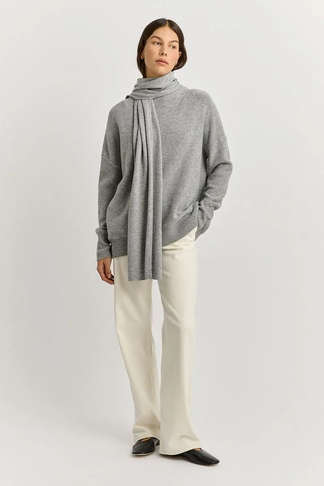 Woman wearing the light ash (pale grey) colour variant of the Toorallie Extra Fine Wool Scarf made from 100% Merino lambswool)