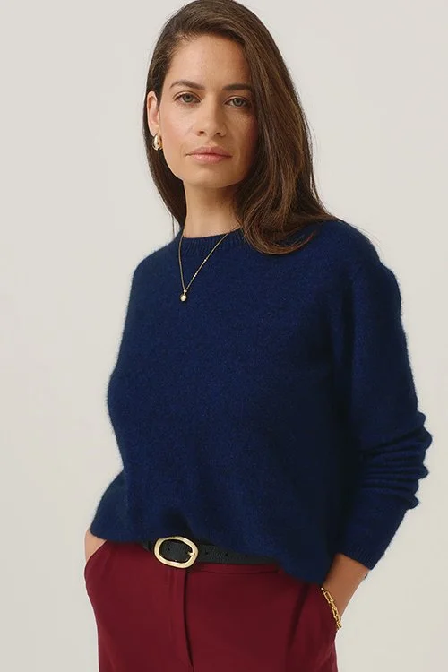 Woman wearing the Merinomink Mia Pullover — Merino Wool, Possum Fur, Silk, in the Zephyr colour variant, a rich dark blue.