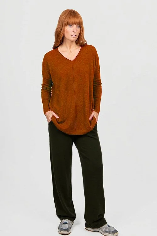 Woman wearing the Bridge & Lord | Queen Vee Curved Hem Pullover made from Merino wool and cashmere in the Cognac (rich brown) colour variant