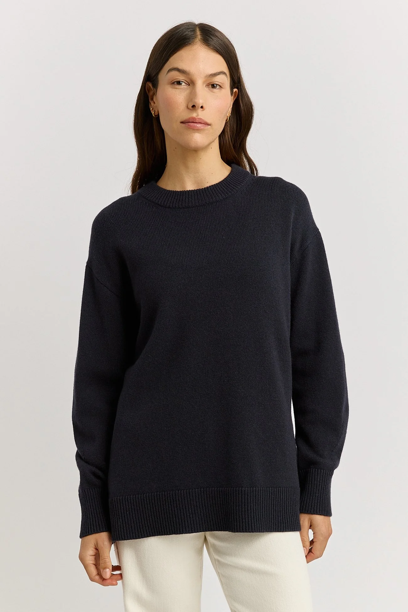 Woman wearing the French Navy Blue colour variant of the Toorallie Relaxed Longline Crew Sweater made from 100% Merino lambswool