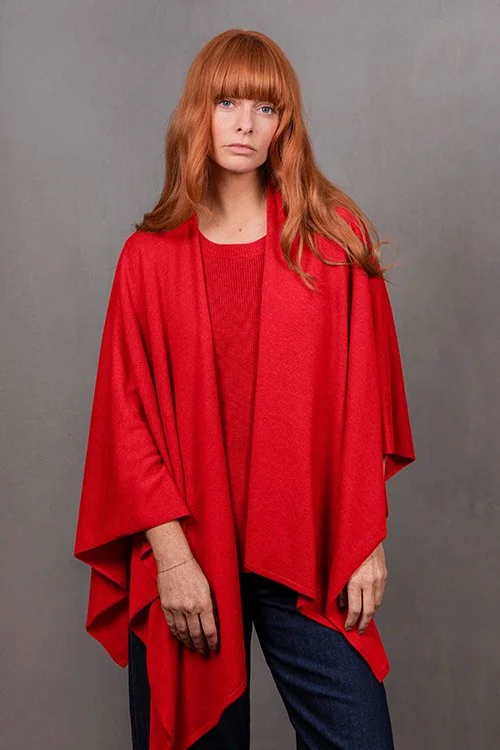 Woman wearing the cayenne red colour variant of the Wrap Topper made from Merino wool and cashmere from Bridge & Lord