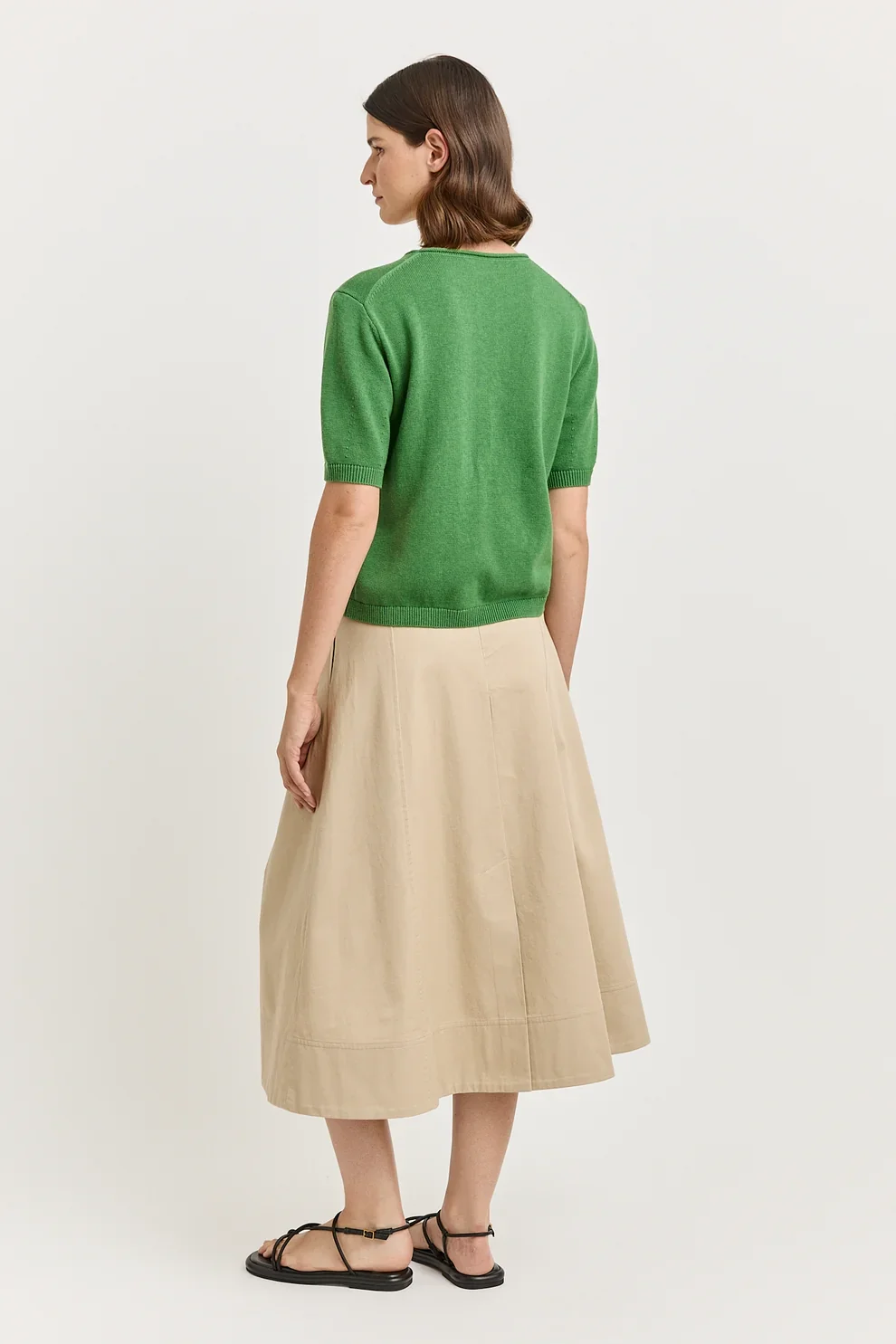 Back view of a woman wearing the Spring (green) colour variant of the Toorallie Links Cap Sleeve Top made from Organic Cotton and Merino