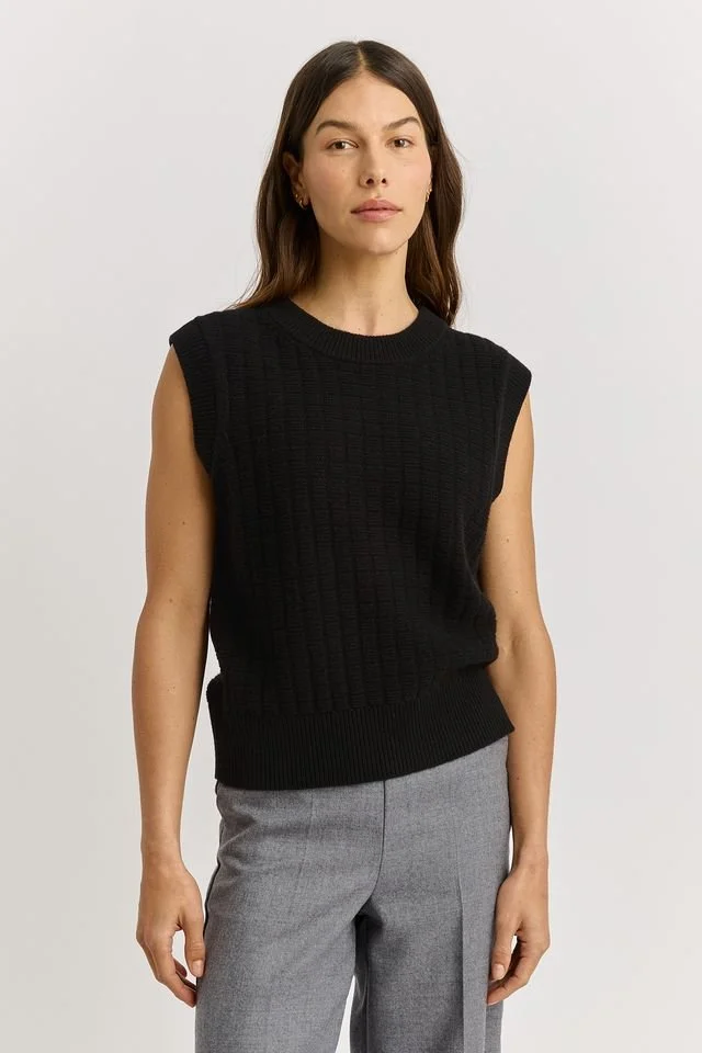 Woman wearing the black variant of the Toorallie Toorallie Grid Knit Vest, made from Merino Lambswool.