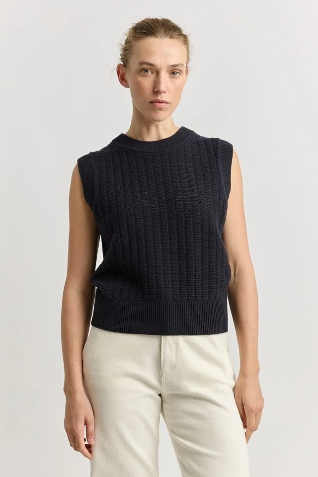 Woman wearing the navy variant of the Toorallie Toorallie Grid Knit Vest, made from Merino Lambswool.