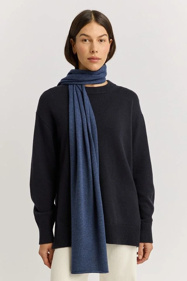 Woman wearing the Galaxy (blue) colour variant of the Toorallie Extra Fine Wool Scarf made from 100% Merino lambswool)