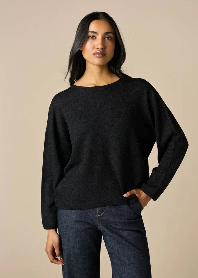 Woman wearing a uimi knitwear | Phoebe Jersey Top (100% Merino wool) in the black colour variant.