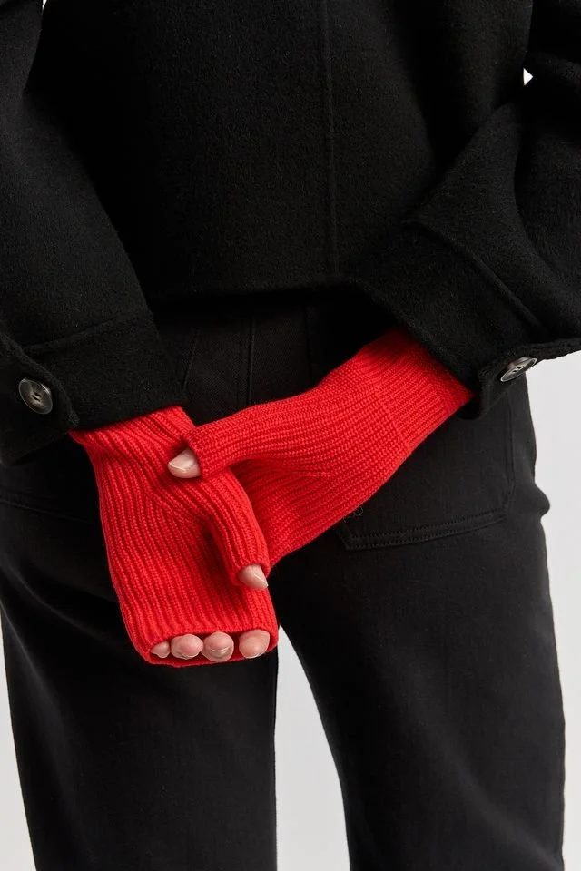 Woman wearing the Poppy red colour variant of the Toorallie open mitten.