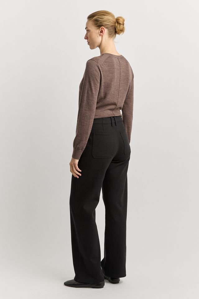 Back view of the black version of the Toorallie Wide-leg-merino-denim jean worn by a woman.