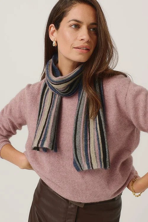 Woman wearing the Merinomink  Ziggy Scarf, made from Merino Wool, Possum Fur, and Silk, in the river blue and rose pink colour way variant.