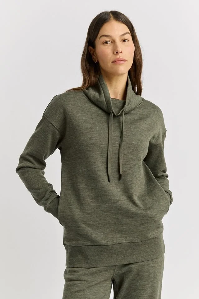 Woman wearing the Toorallie | Lounge Funnel Neck Sweater (Merino wool + Cotton), Kale (olive green) colour variant