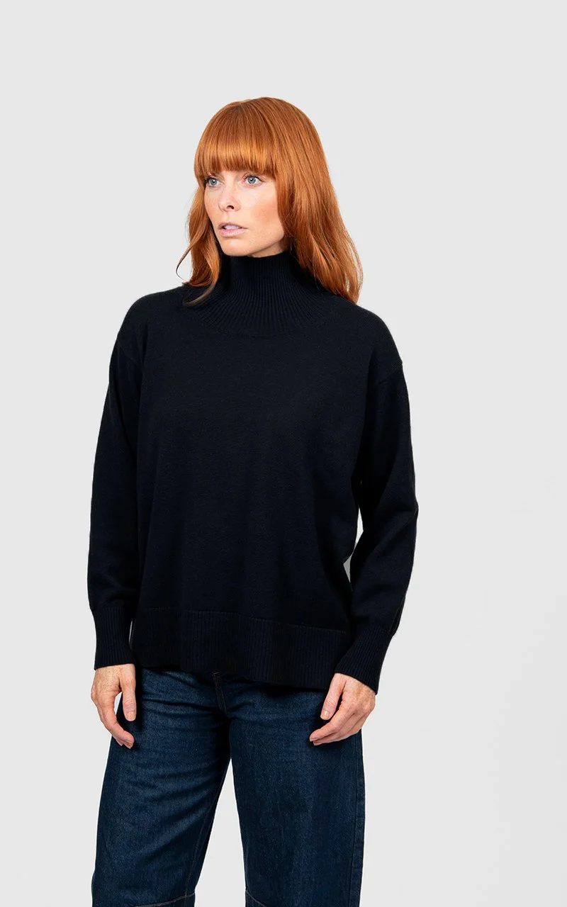 Woman wearing the black colour variant in the Bridge & Lord | Boxy Rib Funnel Neck Pullover made from Merino wool and cashmere