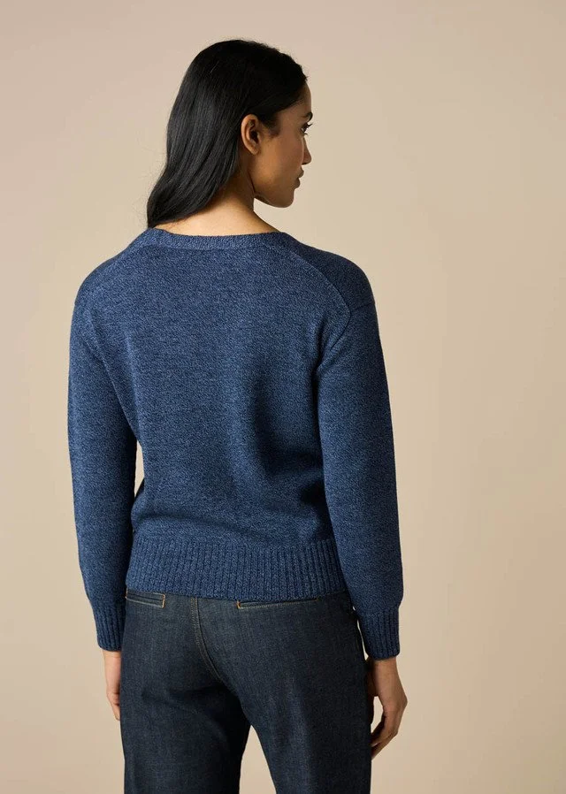 Back view of a woman wearing the denim blue colour variant of the uimi knitwear | Agnes Jersey V-neck Cardigan made from 100% Merino wool.