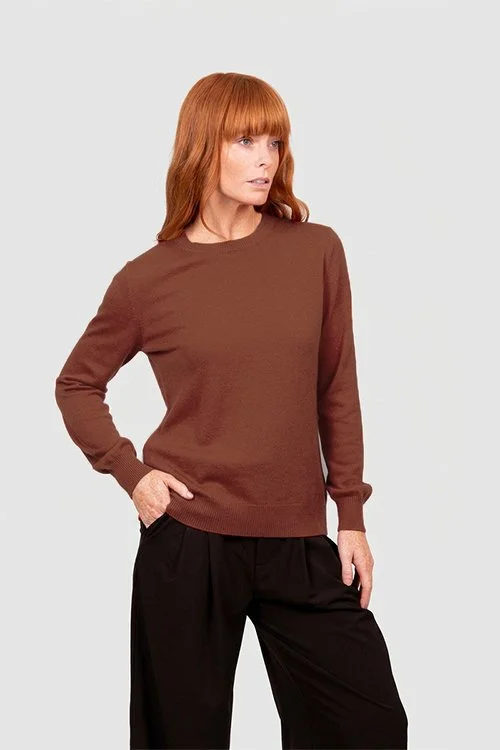 Woman wearing the Cognac (rich brown) colour variant of the Bridge & Lord crew neck jumper