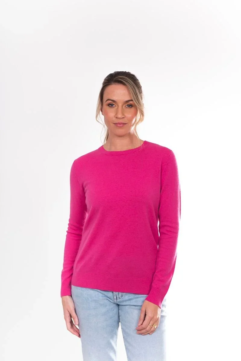 Woman wearing the Chateau rose (rich pink) colour variant of the Bridge & Lord crew neck jumper
