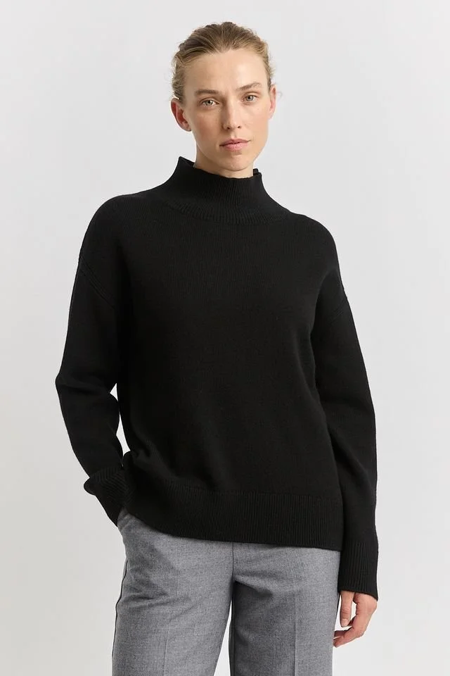 Woman wearing the black colour variant of the Split Neck Funnel Jumper  from Toorallie