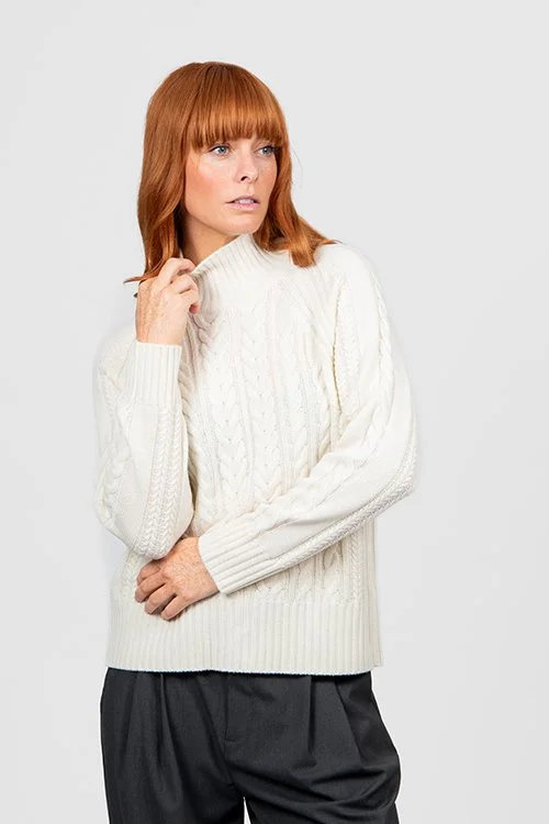 Woman wearing the ivory colour variant of the Cable Raglan Pullover from Bridge & Lord.