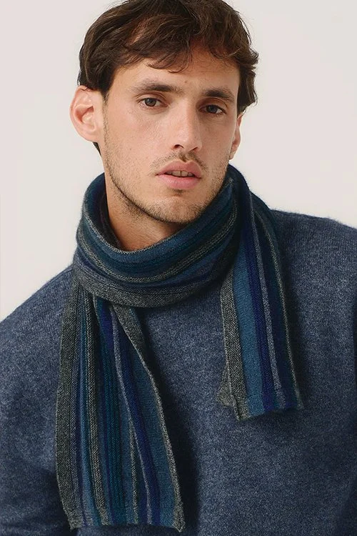 Man wearing the Merinomink  Ziggy Scarf, made from Merino Wool, Possum Fur, and Silk, in the slate grey and river blue colour way variant.