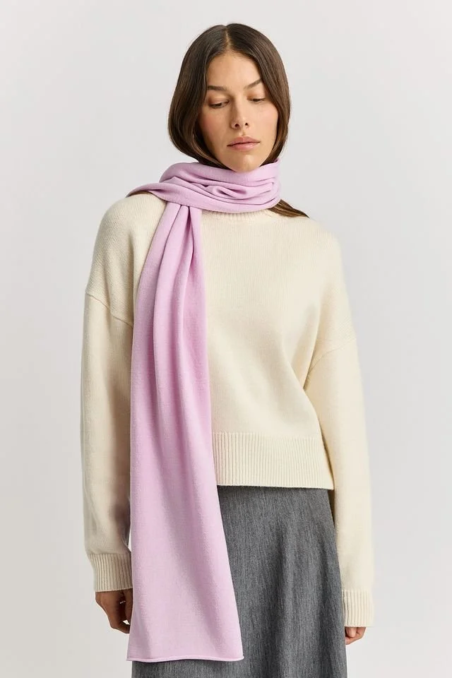 Woman wearing the Powder Pink colour variant of the Toorallie Extra Fine Wool Scarf made from 100% Merino lambswool)